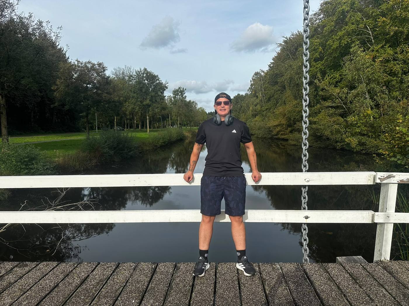 Ethan leunt op de leuning van een houten brug